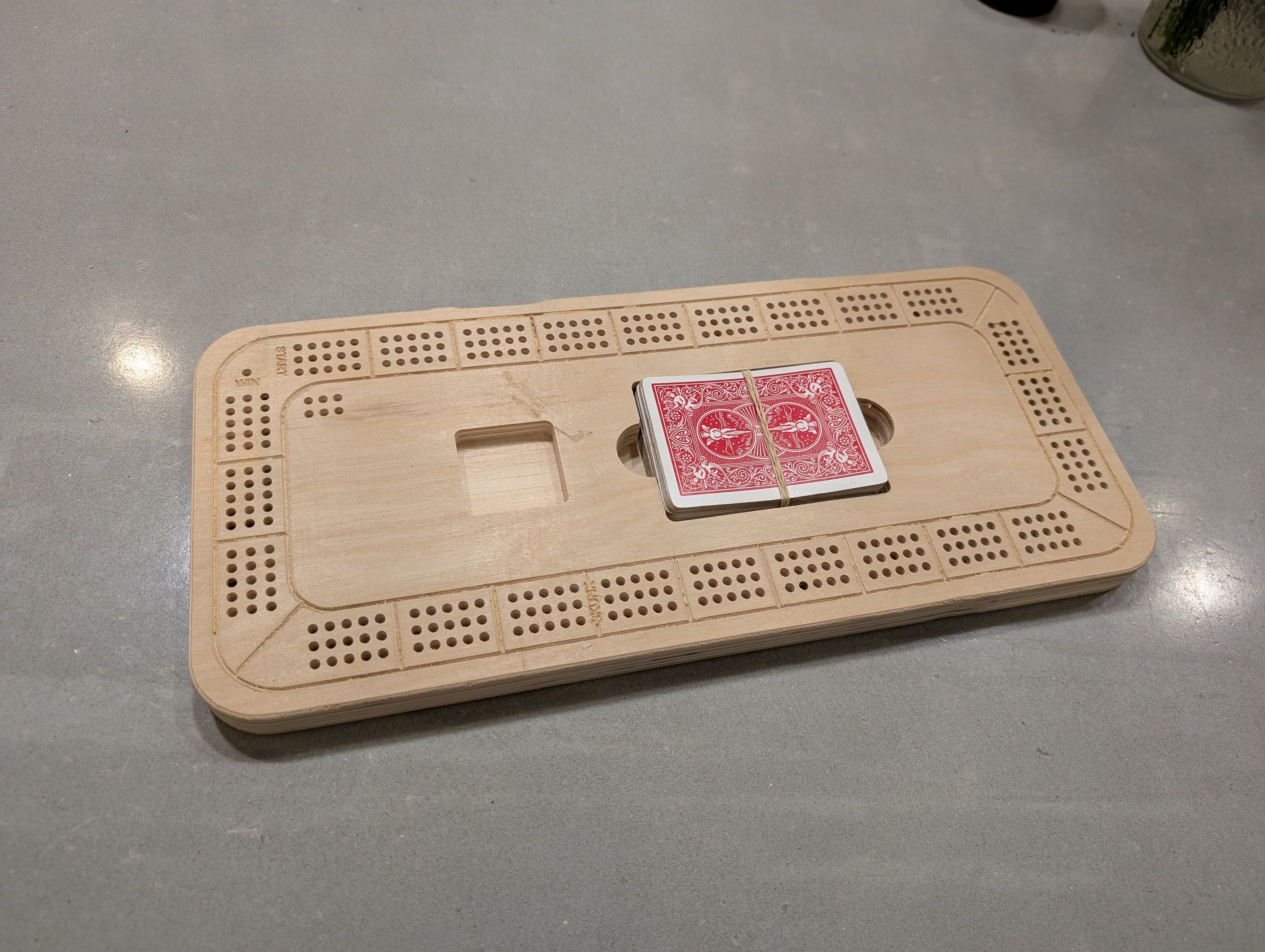 CNC cut wooden game board with drilled holes